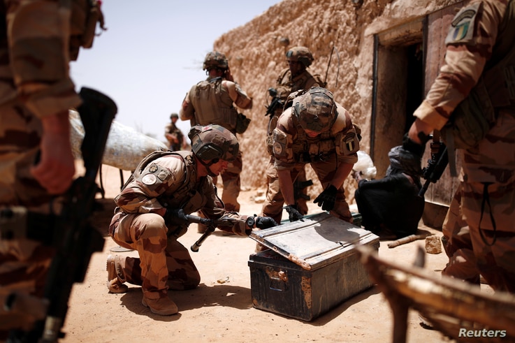 French soldiers of the 2nd Foreign Engineer Regiment search a metal case during an area control operation in the Gourma region…