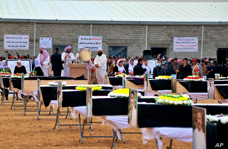 Mourners prepare to bury the remains of Yazidi victims in a cemetery in Sinjar, Iraq, Saturday, Feb. 6, 2021. 104 Yazidi killed by the Islamic State group six years ago were given a proper burial in a cemetery in Sinjar's Kocho village in the country's north. 