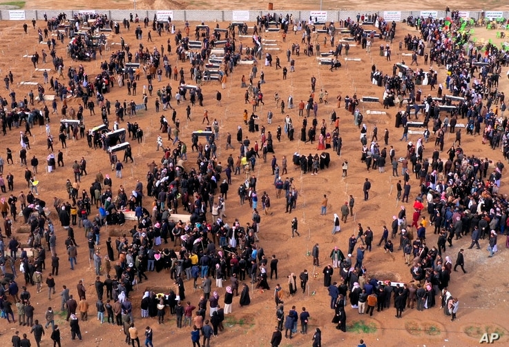 An aerial view of mourners preparing to bury the remains of Yazidi victims in a cemetery in Sinjar, Iraq, Feb. 6, 2021.