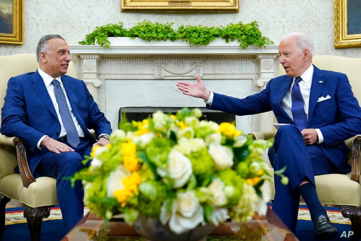 President Joe Biden, right, speaks as Iraqi Prime Minister Mustafa al-Kadhimi, left, listens during their meeting in the Oval…