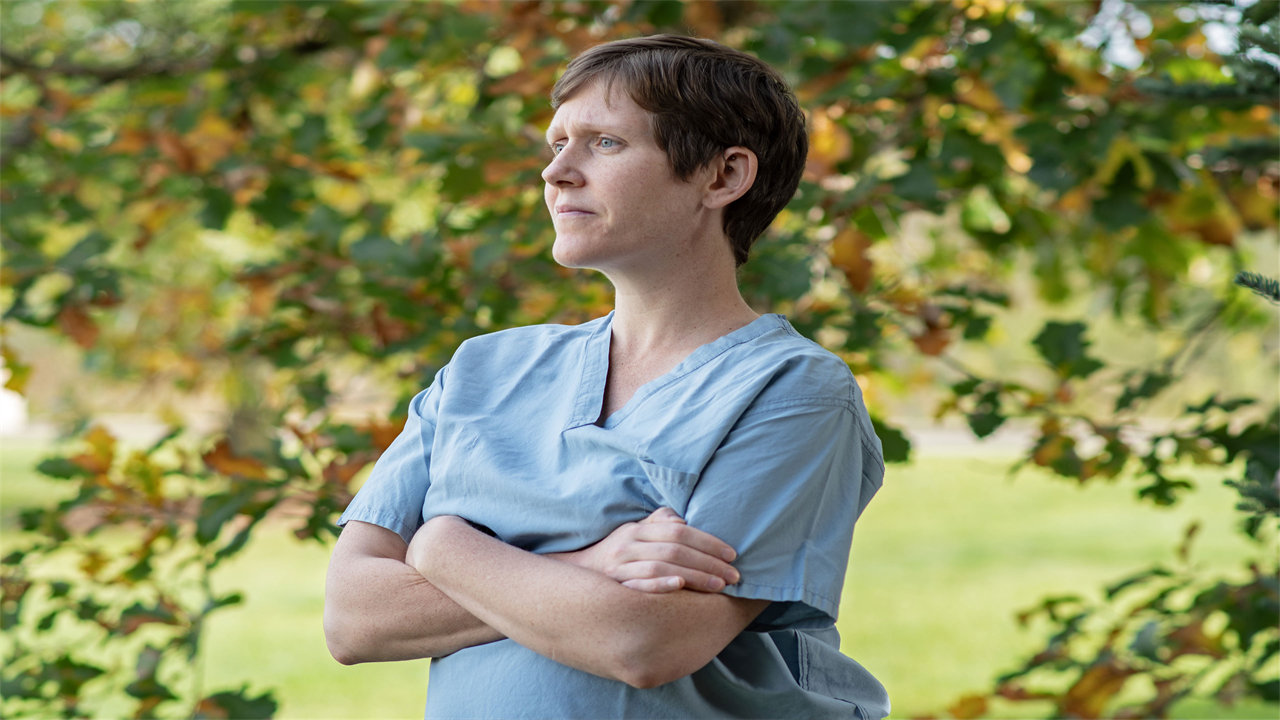 A photo of an OB-GYN posing for a portrait outside.