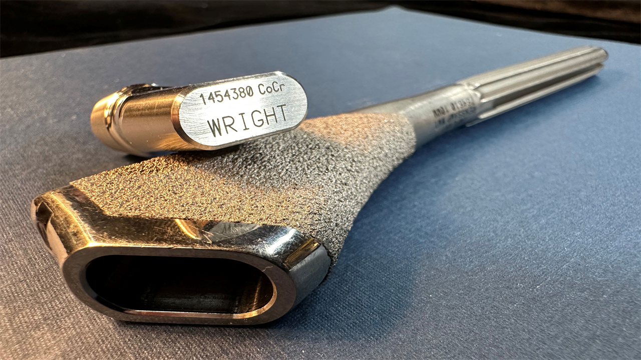 A photo of a Profemur implant resting on a flat surface.