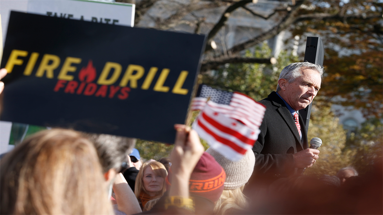 A photo of Robert F. Kennedy Jr. speaking before a crowd of protesters.