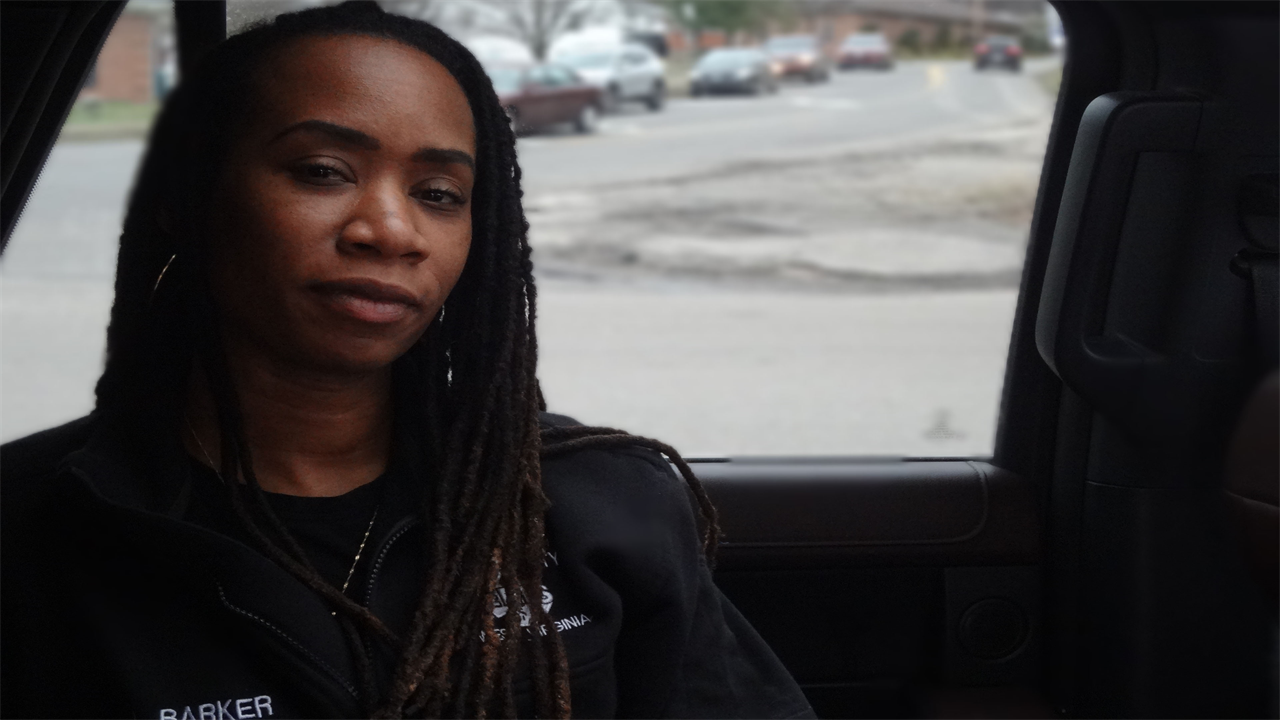 Larrecsa Barker looks towards the camera. She wears a sweatshirt that shows her name, "Barker."