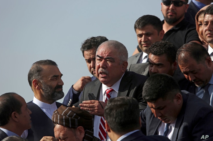 FILE - Abdul Rashid Dostum, center, a former warlord and Afghanistan's vice president at the time, disembarks with members of his entourage from his plane on arrival at Kabul International Airport, in Kabul, Afghanistan, July 22, 2018. 