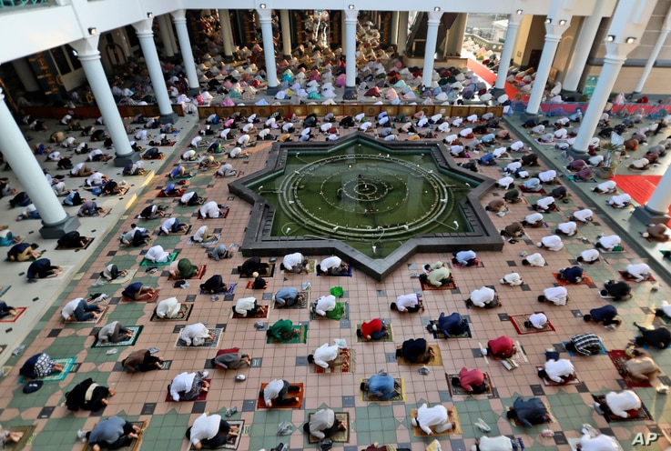 Muslims pray spaced apart to help curb the spread of coronavirus outbreak during an Eid al-Fitr prayer marking the end of…