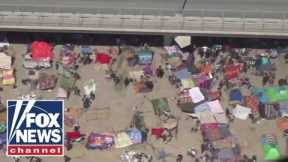 Thousands of migrants shelter in a tent city under Texas bridge