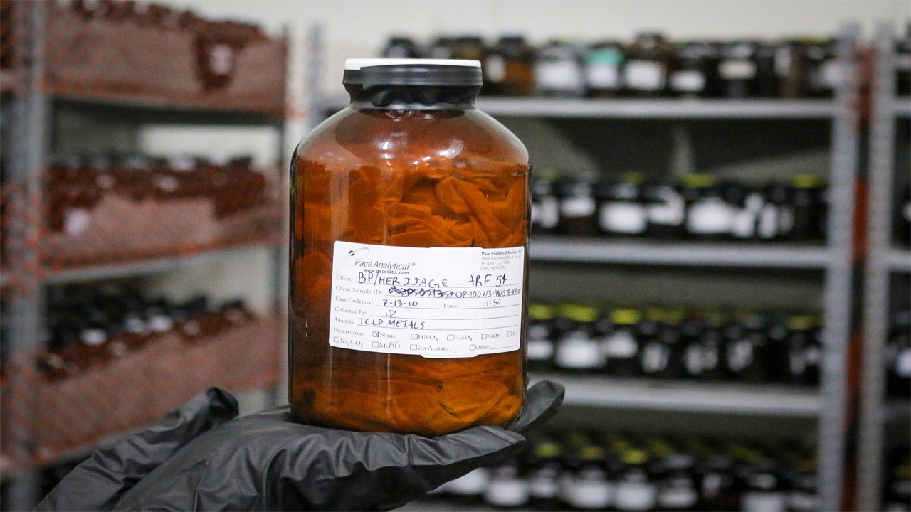 A photo shows gloved hands holding a jar with a cloth inside.