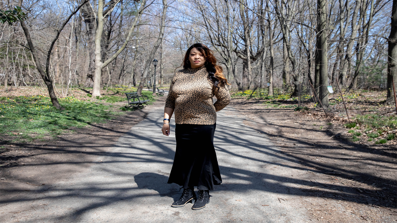 A photo of a woman standing outside at a park.