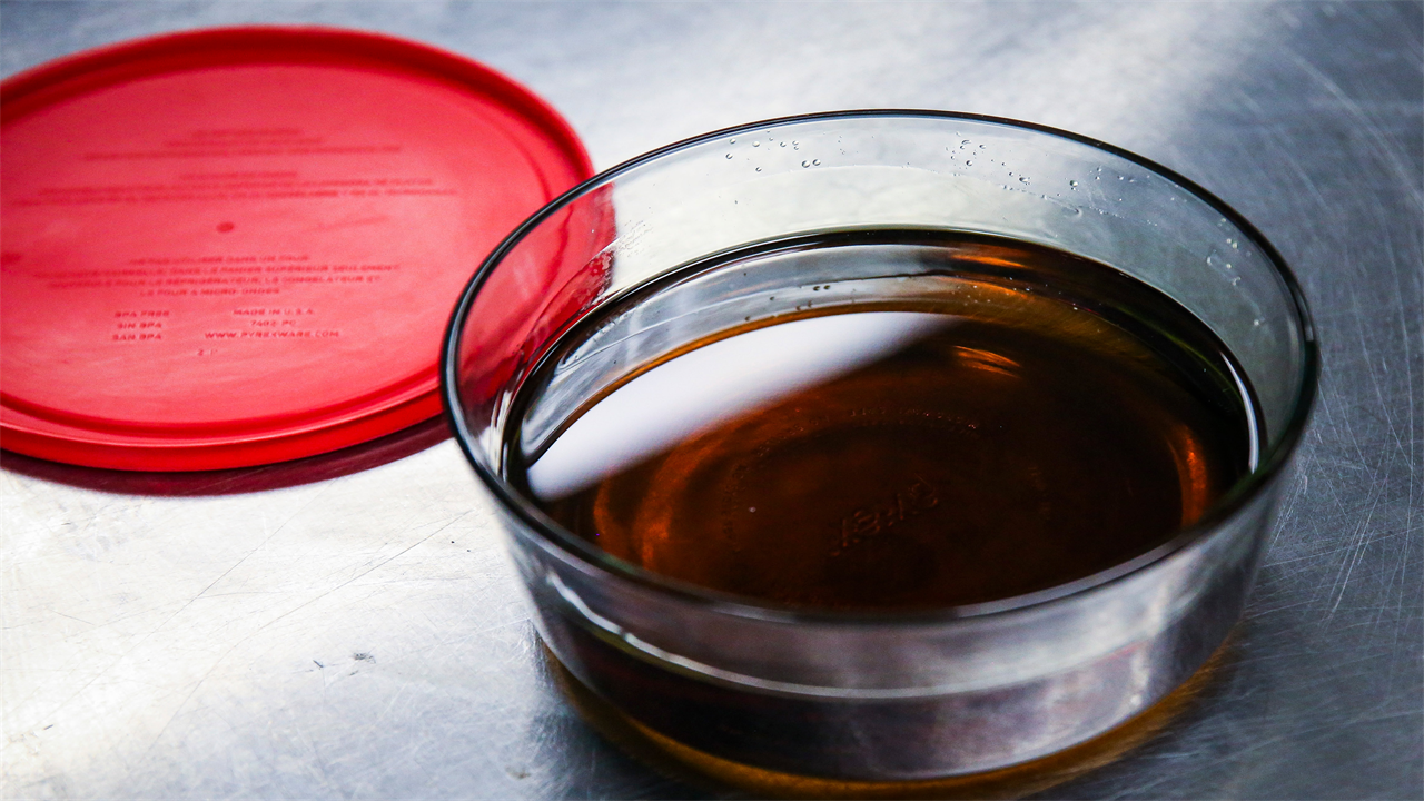 A photo of a glass container filled with liquid marijuana concentrate.