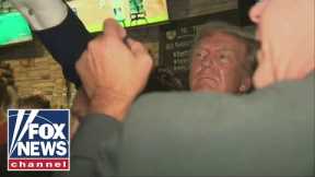 Watch: Donald Trump gets swarmed as he hands out pizza at Iowa pub