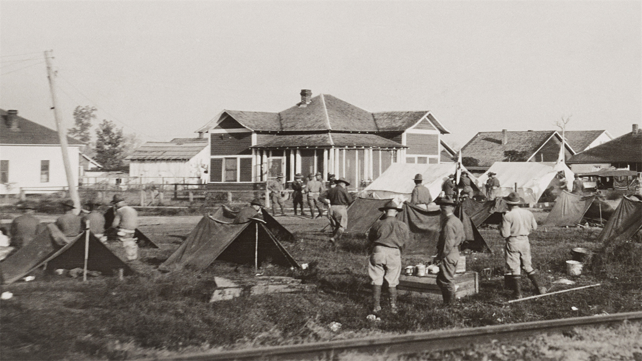 A historic photo from 1919 of soldiers standing in a camp of tents in Elaine, Arkansas.